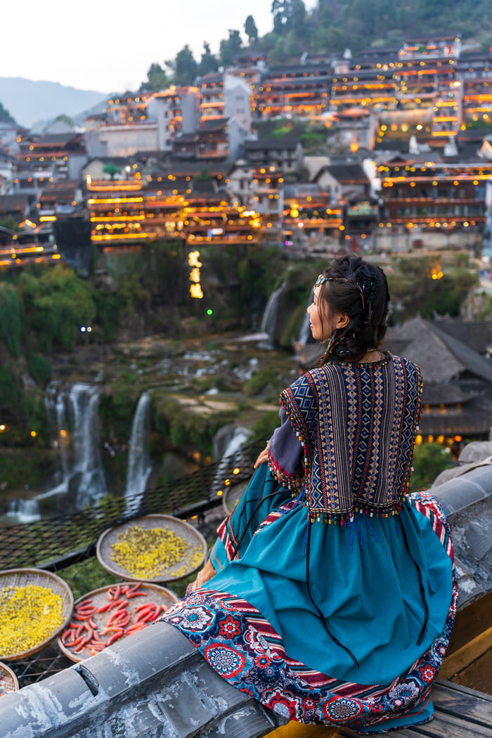 Mujer sentada viendo hacia una ciudad en china